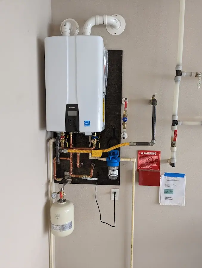 Professional plumber installing copper piping in a Riverdale home